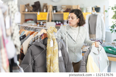 woman chooses outerwear at a sale in a showroom woman chooses outerwear at a sale in a showroom 132517676