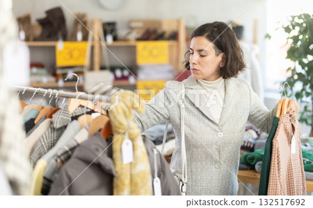 Female buyer chooses a warm dress Female buyer chooses a warm dress 132517692