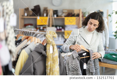 woman chooses outerwear at a sale in a showroom woman chooses outerwear at a sale in a showroom 132517701