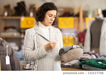 Woman choosing a knitted hat Woman choosing a knitted hat 132517788