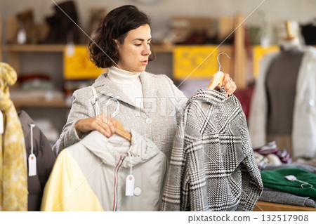 woman chooses outerwear at a sale in a showroom 132517908