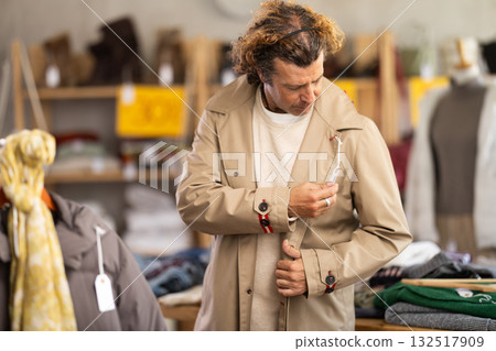 man chooses a beige trench coat man chooses a beige trench coat 132517909