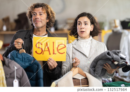 Couple on sale in a store with a poster Couple on sale in a store with a poster 132517984