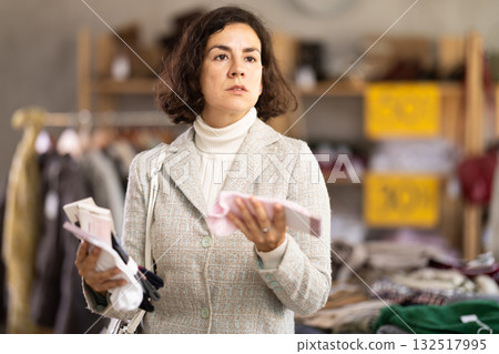 Latin American woman search and choose socks in shop Latin American woman search and choose socks in shop 132517995