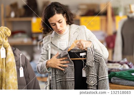 woman chooses outerwear at a sale in a showroom woman chooses outerwear at a sale in a showroom 132518083