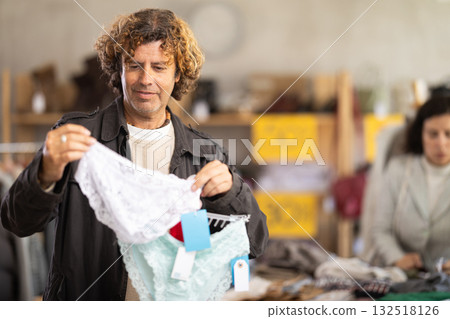 Man search and choose ladys lace panties in store 132518126