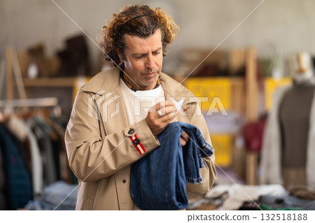 Man search and choose jeans trousers in store 132518188