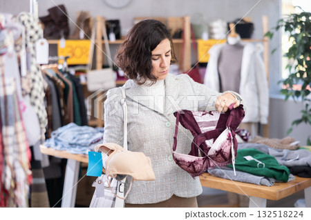 Adult woman choosing bras in store Adult woman choosing bras in store 132518224