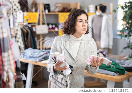 Latin American woman search and choose socks in shop 132518371