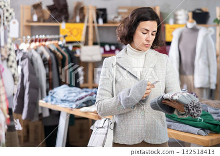 Woman choosing a knitted hat Woman choosing a knitted hat 132518413