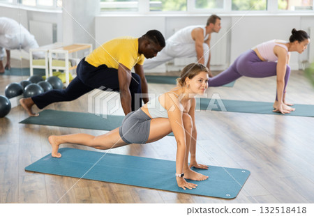 Girl doing Runners Lunges during group pilates session Girl doing Runners Lunges during group pilates session 132518418