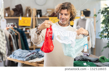 man chooses panties in a clothing store for his wife 132518603