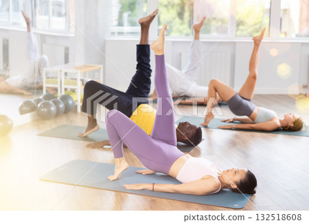 During training girl leads multinational class, performs exercises to strengthen muscles of press During training girl leads multinational class, performs exercises to strengthen muscles of press 132518608