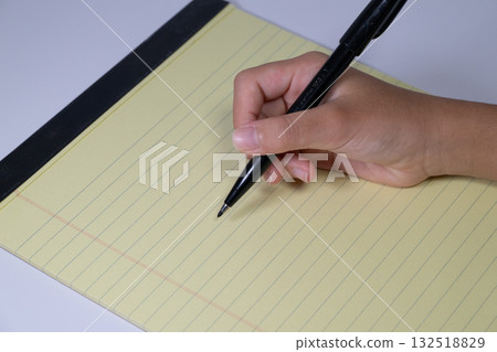 Hand holding a pen on a yellow report form 132518829