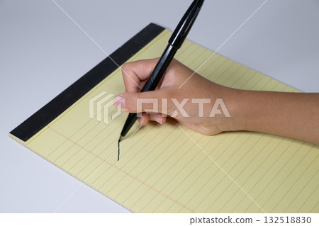 Hand writing with a pen on a yellow report paper 132518830