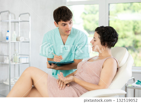 Doctor cosmetologist writes down the complaints of female patient in cosmetology clinic Doctor cosmetologist writes down the complaints of female patient in cosmetology clinic 132519052