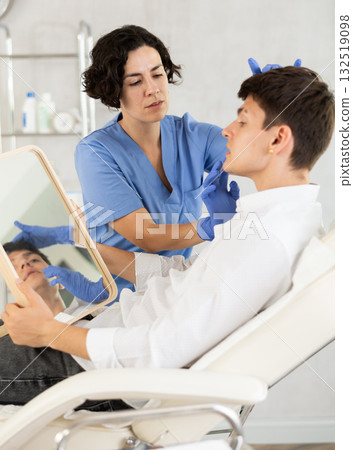 Young man having consultation about face aesthetic while looking in the mirror 132519098