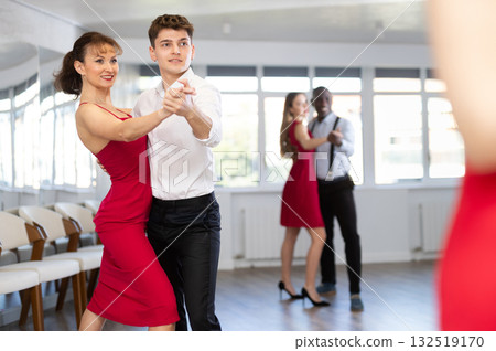 Young man and woman dancing waltz in couple during lesson at studio Young man and woman dancing waltz in couple during lesson at studio 132519170
