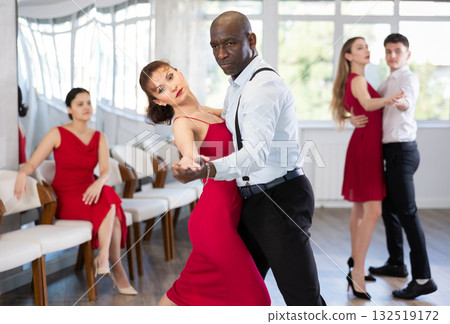 African man and woman dancing waltz in couple during lesson at studio 132519172