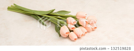 Peach colored tulips create a romantic atmosphere, perfect for celebrating valentine's day, women's day, mother's day, or simply enjoying the beauty of spring, lying gracefully on a table Peach colored tulips create a romantic atmosphere, perfect for celebrating valentine's day, women's day, mother's day, or simply enjoying the beauty of spring, lying gracefully on a table 132519828