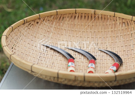 Rice harvesting sickles arranged on a bamboo basket Rice harvesting sickles arranged on a bamboo basket 132519964