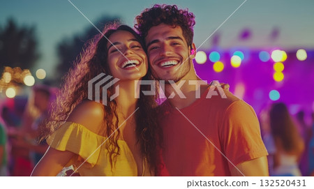 Young couple laughing and enjoying a live music performance at an outdoor summer music festival, creating a joyful and memorable experience 132520431