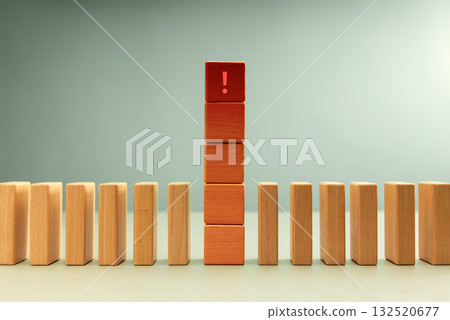 Red wooden block with exclamation mark standing among dominoes 132520677
