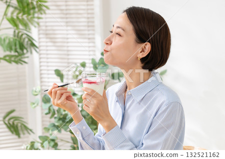 Woman eating yogurt Woman eating yogurt 132521162