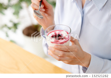 Woman eating yogurt Woman eating yogurt 132521282