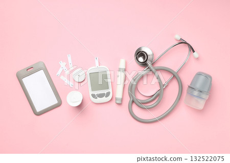 Various diabetes management tools placed on pink surface 132522075