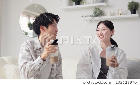 Asian men and women drinking protein in the living room 132523970