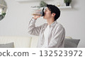 Asian man drinking protein in the living room 132523972
