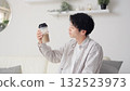 Asian man looking at protein shake in living room 132523973