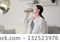 Asian woman drinking protein in the living room 132523976