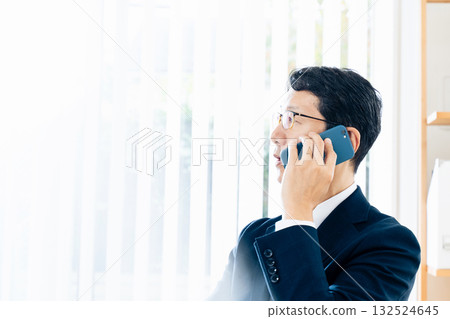 A middle-aged businessman talking on a smartphone 132524645