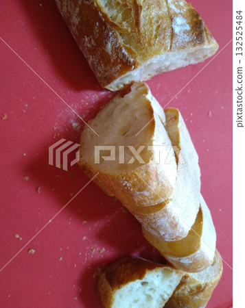 Red cutting board and sliced baguette Red cutting board and sliced baguette 132525484