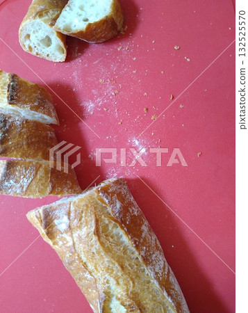 Handmade baguettes arranged on a red plate 132525570