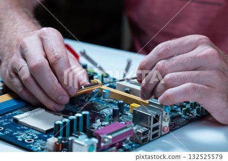 A master repairs a motherboard from a computer 132525579