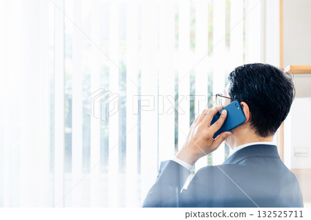 A middle-aged businessman talking on a smartphone A middle-aged businessman talking on a smartphone 132525711