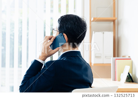 A middle-aged businessman talking on a smartphone 132525713