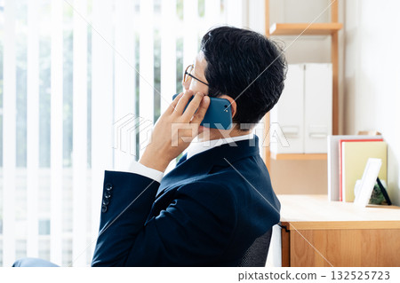 一個中年商人談話在智能手機 132525723