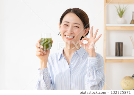 A woman drinking green juice 132525871