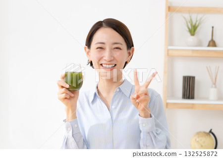 A woman drinking green juice 132525872