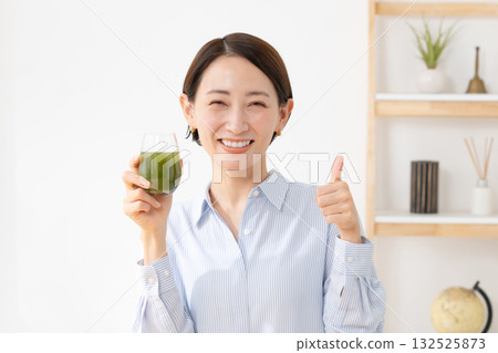 A woman drinking green juice A woman drinking green juice 132525873