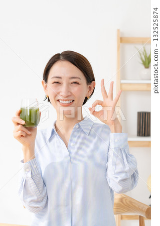 A woman drinking green juice A woman drinking green juice 132525874