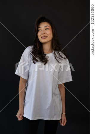 Casual apparel presentation of smiling model in studio with relaxing pose and subtle lighting Casual apparel presentation of smiling model in studio with relaxing pose and subtle lighting 132525890