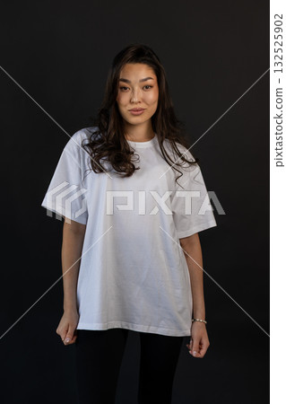 Casual apparel presentation of smiling model in studio with relaxing pose and subtle lighting 132525902