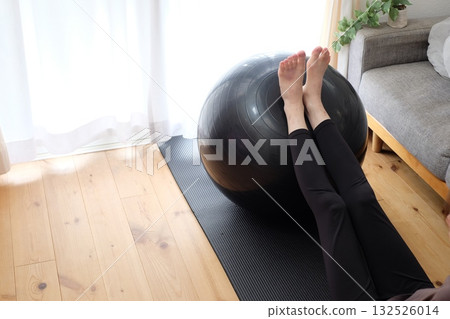 A woman who puts a foot on the balance ball 132526014