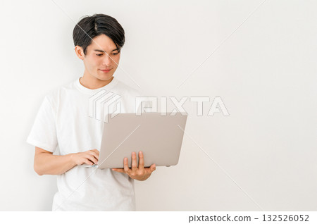 一位身穿 T 卹、手持筆記型電腦的亞洲年輕男子(自由工作者、創作者、程式設計師) 一位身穿 T 卹、手持筆記型電腦的亞洲年輕男子(自由工作者、創作者、程式設計師) 132526052