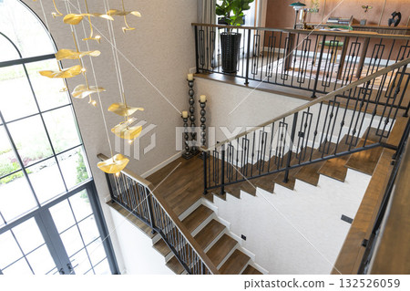 Home entrance hallway with modern chandelier and stairway leading to second floor. 132526059